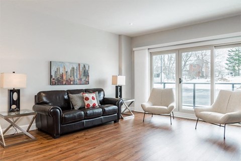 a living room with a leather couch and a large window